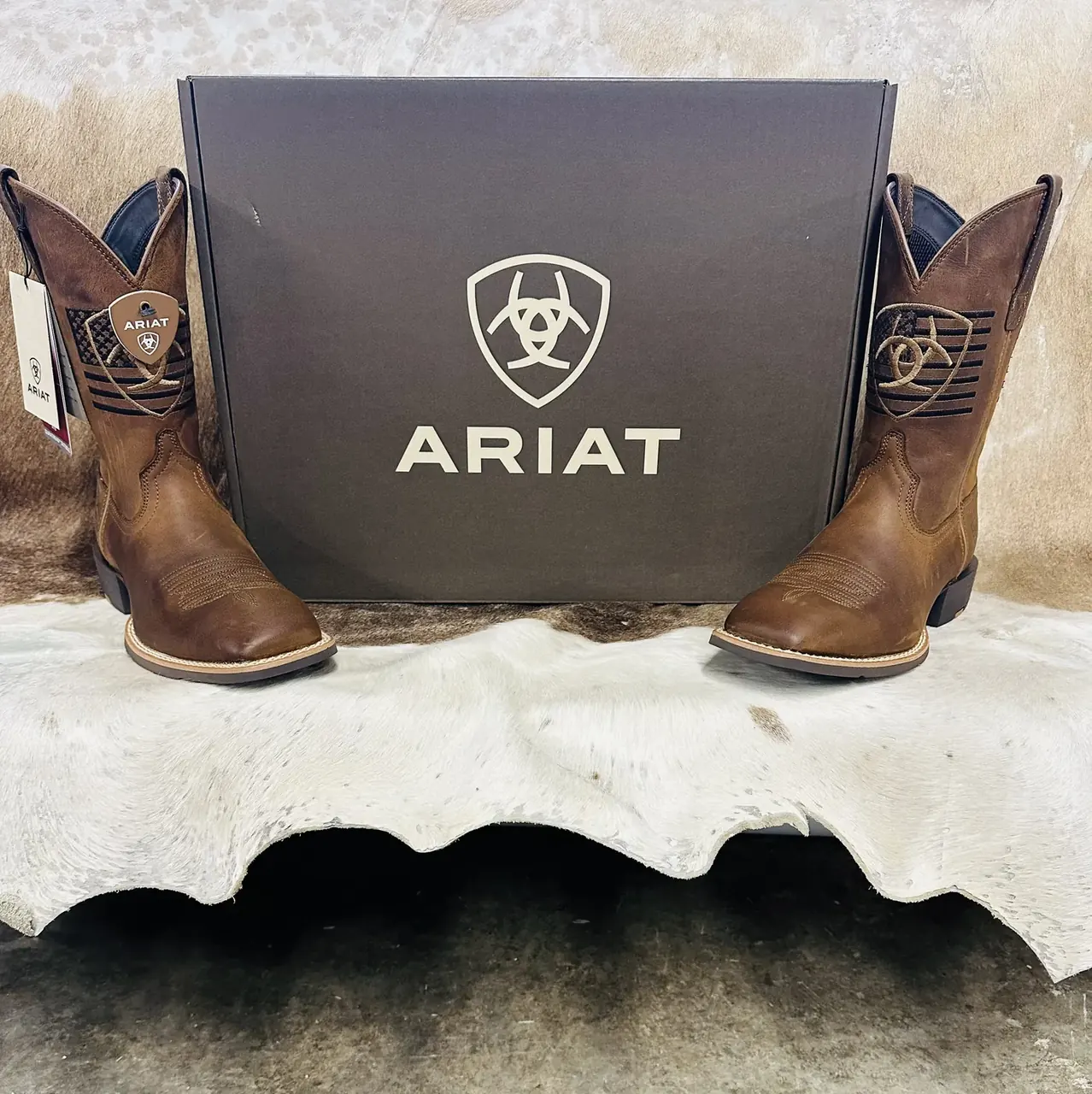 Ariat cowboy boots with Ariat box on cowhide