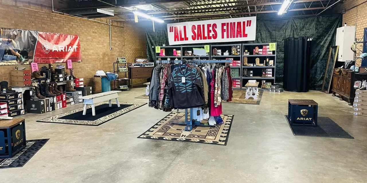 Cowboy Country Western Wear Clearance Store with Ariat banner, boots and marked-down clothing racks