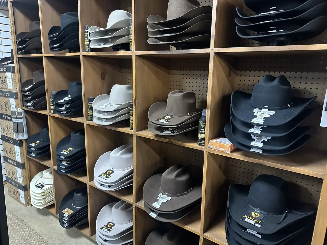 Felt cowboy hats from Stetson, Ariat and Twister on the shelf wall