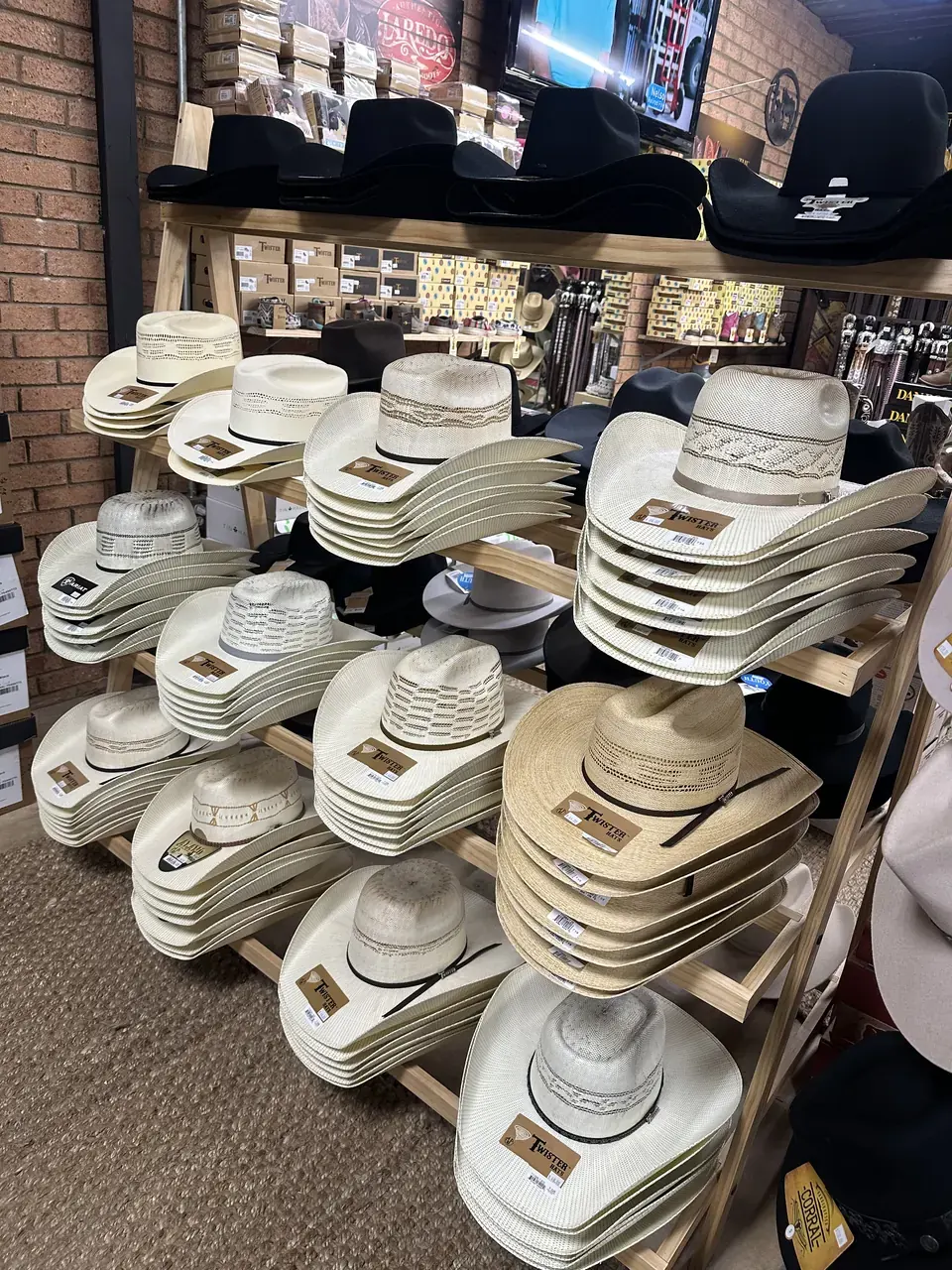 Straw cowboy hats from Twister and Ariat displayed in store